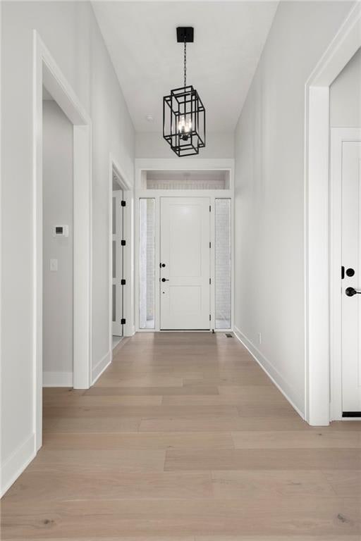 entrance foyer with a notable chandelier and light hardwood / wood-style flooring