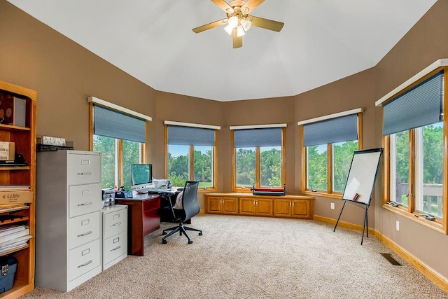 office area featuring ceiling fan, light colored carpet, vaulted ceiling, and a healthy amount of sunlight