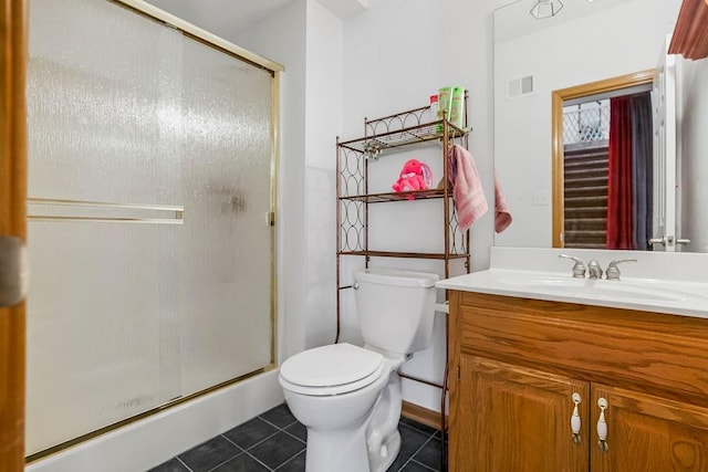 bathroom featuring vanity, a shower with shower door, toilet, and tile patterned flooring