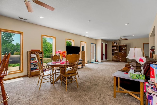 dining space with ceiling fan and carpet flooring