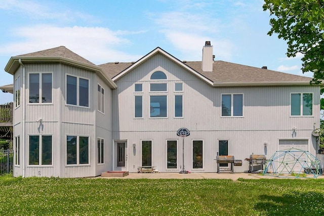 rear view of house featuring a garage and a yard