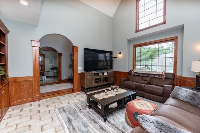 living room featuring a high ceiling and wood walls