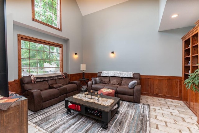 living room with high vaulted ceiling and wood walls