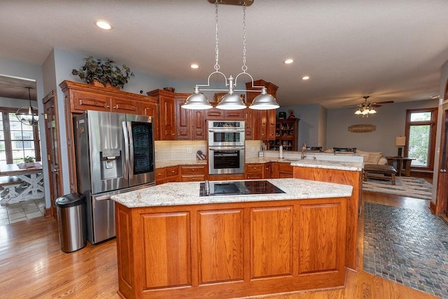 kitchen featuring pendant lighting, a center island, kitchen peninsula, and appliances with stainless steel finishes