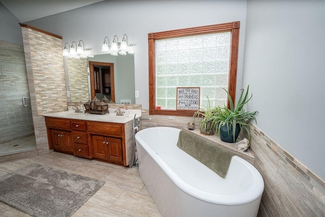 bathroom with plus walk in shower, tile walls, and vanity