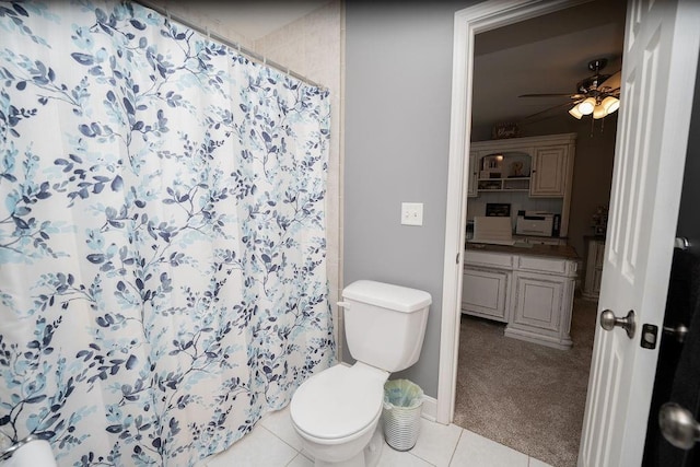 bathroom with curtained shower, tile patterned floors, ceiling fan, and toilet