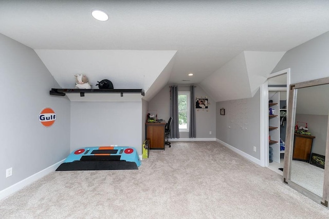 interior space with light carpet and vaulted ceiling