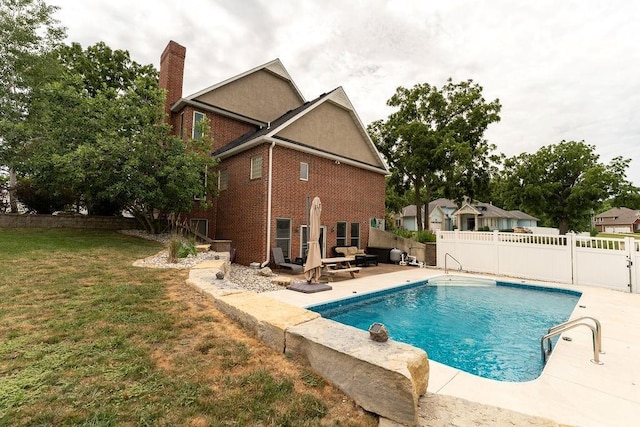 view of swimming pool featuring a lawn and a patio area