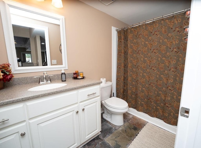 bathroom with vanity, curtained shower, and toilet