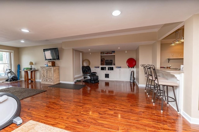 living room with hardwood / wood-style flooring and indoor bar