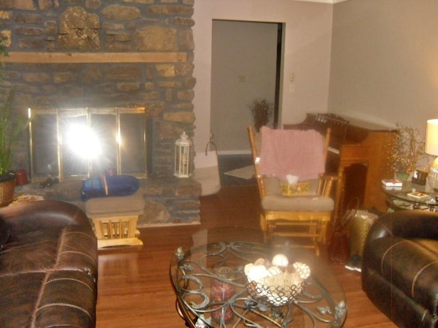 living room featuring hardwood / wood-style flooring and a stone fireplace