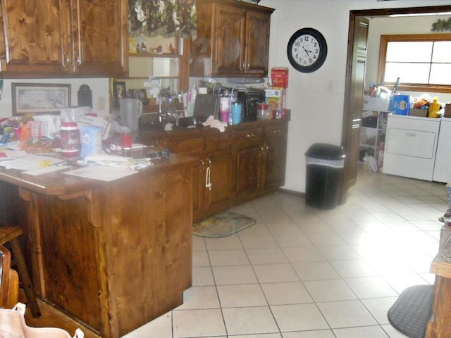 kitchen featuring light tile patterned flooring and washing machine and clothes dryer