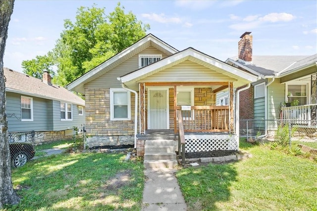 bungalow-style house featuring covered porch and a front lawn