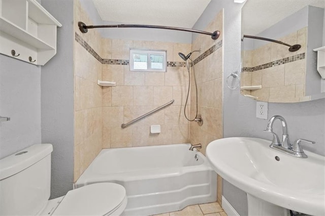 full bathroom with toilet, a textured ceiling, tile patterned floors, tiled shower / bath combo, and sink