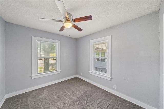 carpeted spare room with ceiling fan and plenty of natural light