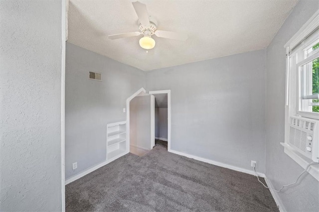 unfurnished room featuring a textured ceiling, ceiling fan, and carpet