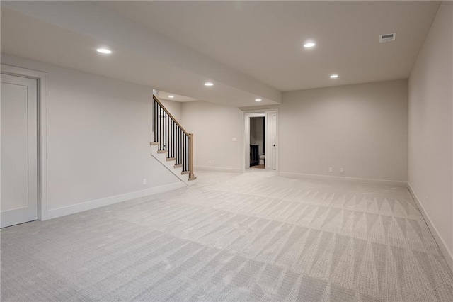 finished below grade area featuring visible vents, recessed lighting, baseboards, light colored carpet, and stairs