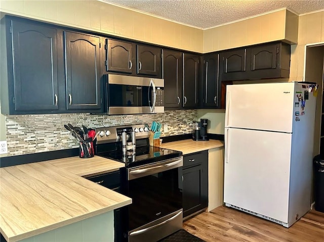 kitchen with decorative backsplash, a textured ceiling, appliances with stainless steel finishes, and light hardwood / wood-style flooring