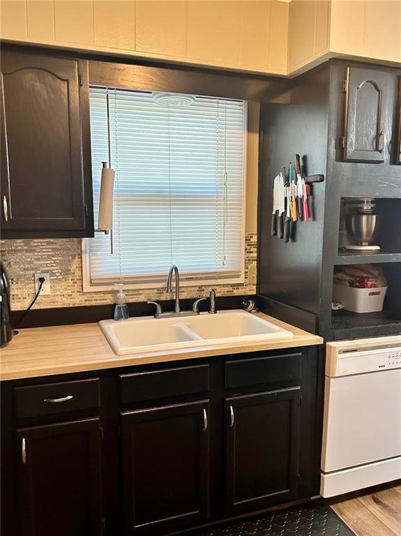 kitchen featuring dishwasher, dark wood-type flooring, dark brown cabinets, and sink