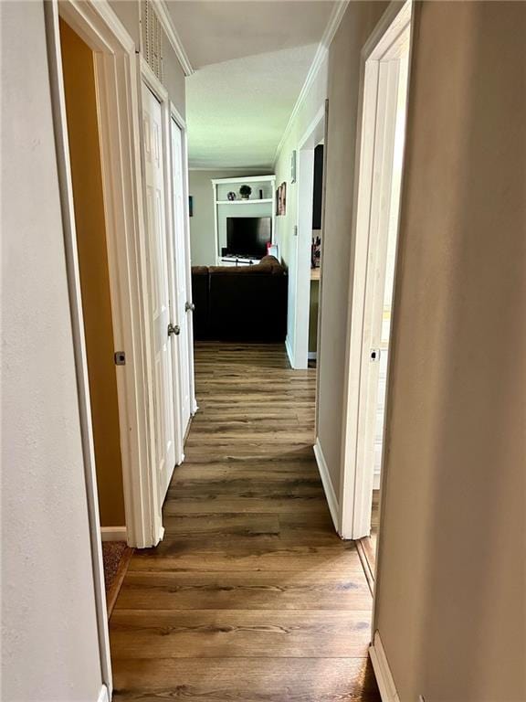 hallway featuring crown molding and dark hardwood / wood-style floors