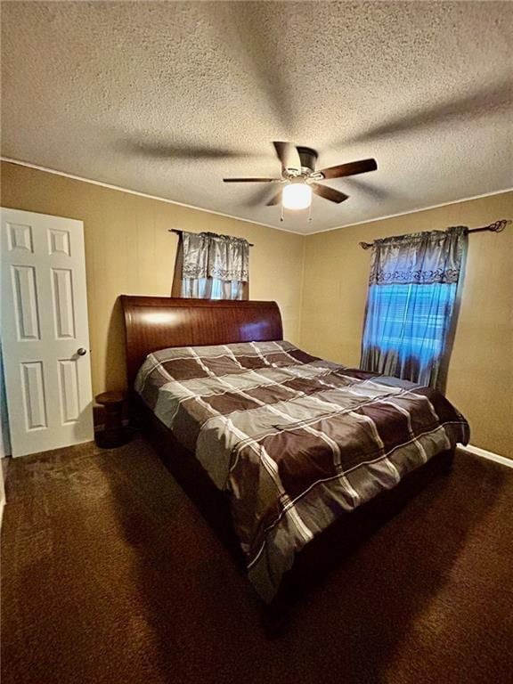 carpeted bedroom featuring ceiling fan and a textured ceiling