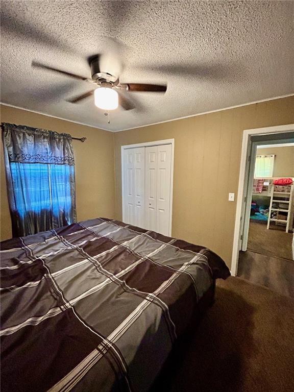 bedroom featuring a textured ceiling, a closet, ceiling fan, and carpet floors