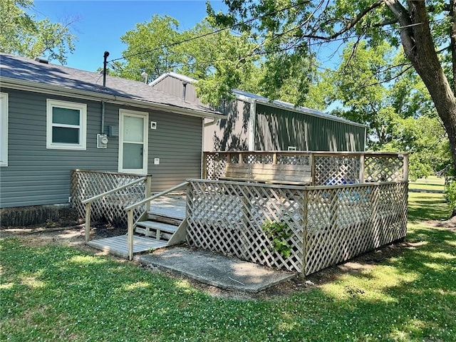 rear view of house with a lawn and a wooden deck