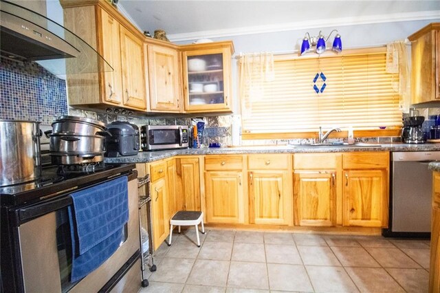 kitchen with backsplash, appliances with stainless steel finishes, sink, and light tile flooring