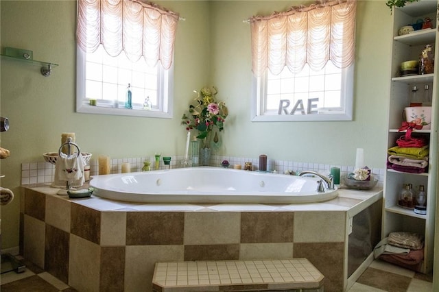 bathroom with a healthy amount of sunlight, a relaxing tiled bath, and tile floors