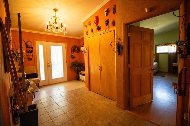 entrance foyer featuring tile floors, ornamental molding, and an inviting chandelier