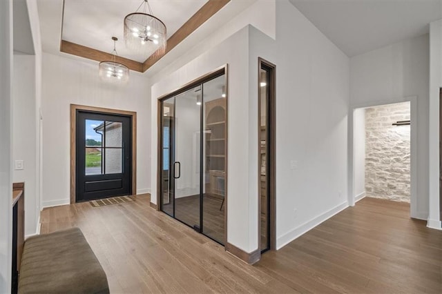 8736 N Lewis Ave, Kansas City, MO 64157 - entryway featuring a chandelier, wood finished floors, a tray ceiling, and baseboards