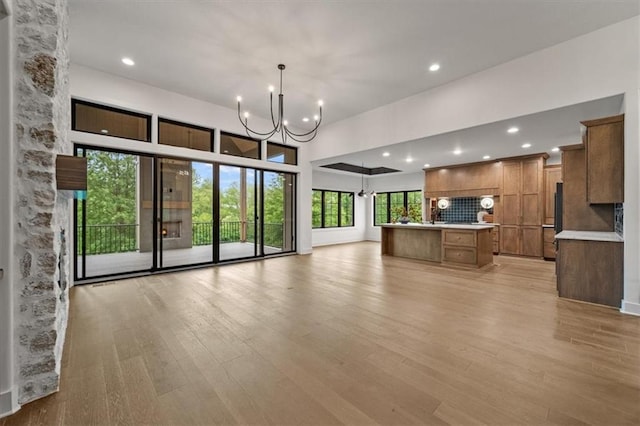 8736 N Lewis Ave, Kansas City, MO 64157 - unfurnished living room featuring a chandelier, light wood-style floors, and recessed lighting