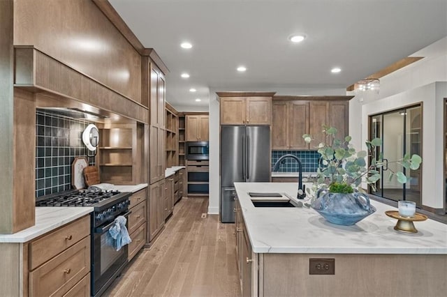 8736 N Lewis Ave, Kansas City, MO 64157 - kitchen featuring high end range, a sink, light wood-style floors, freestanding refrigerator, and tasteful backsplash
