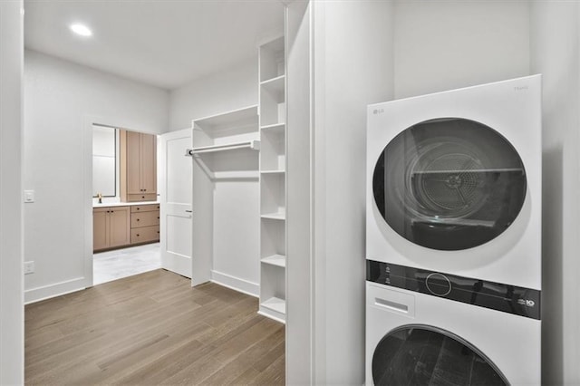 8736 N Lewis Ave, Kansas City, MO 64157 - laundry area featuring estacked washer and dryer, light wood-type flooring, and baseboards