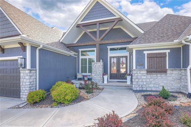 view of exterior entry featuring a garage and french doors