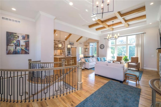 living room featuring a notable chandelier, light wood-type flooring, ornamental molding, beam ceiling, and coffered ceiling