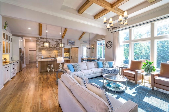 living room featuring an inviting chandelier, lofted ceiling with beams, and hardwood / wood-style floors