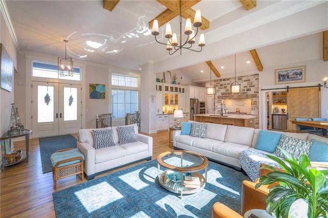 living room featuring beamed ceiling, hardwood / wood-style floors, an inviting chandelier, sink, and high vaulted ceiling