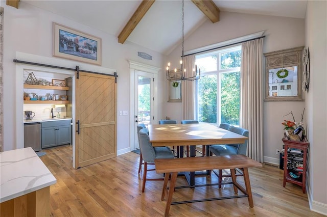 dining room featuring light wood-type flooring, an inviting chandelier, a barn door, lofted ceiling with beams, and sink