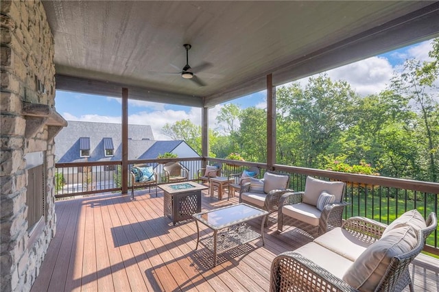 wooden deck featuring outdoor lounge area and ceiling fan