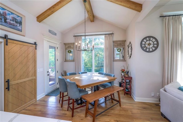 dining room with hardwood / wood-style flooring, vaulted ceiling with beams, a barn door, and plenty of natural light