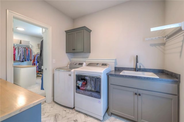 washroom featuring cabinets, independent washer and dryer, and sink