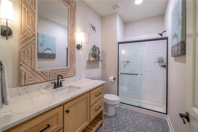 bathroom featuring tile patterned floors, vanity, a shower with shower door, and toilet