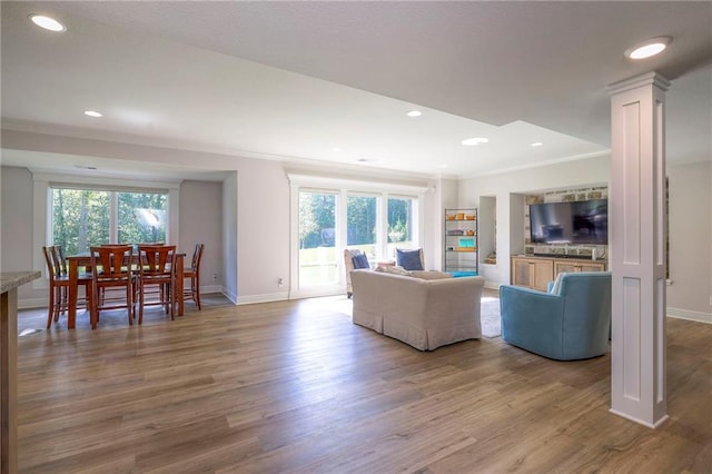 living room featuring crown molding, hardwood / wood-style flooring, and a healthy amount of sunlight