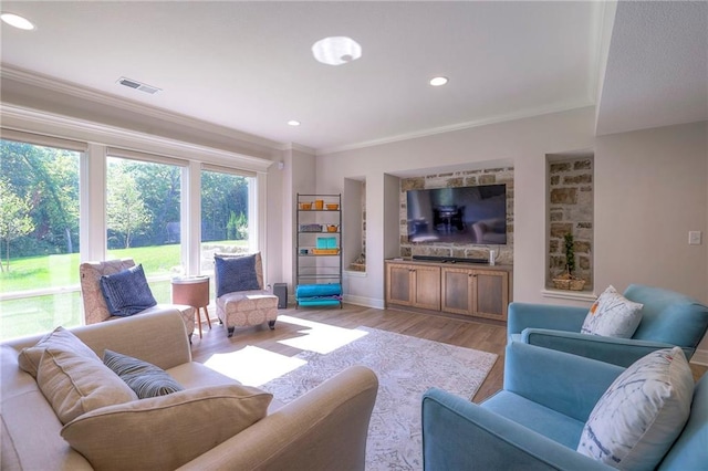 living room featuring crown molding, hardwood / wood-style flooring, and a healthy amount of sunlight