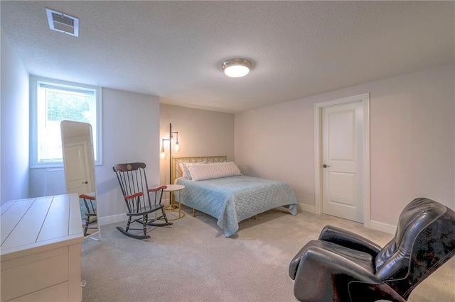 bedroom featuring light colored carpet and a textured ceiling