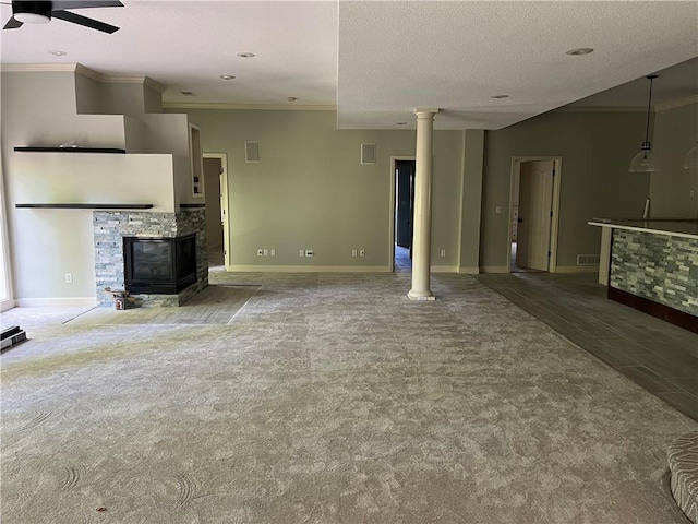 unfurnished living room featuring ceiling fan, a textured ceiling, a fireplace, and ornamental molding