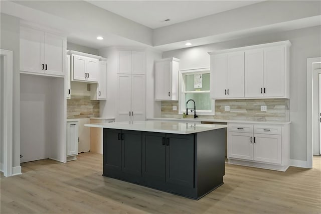 kitchen featuring a center island, sink, and white cabinets