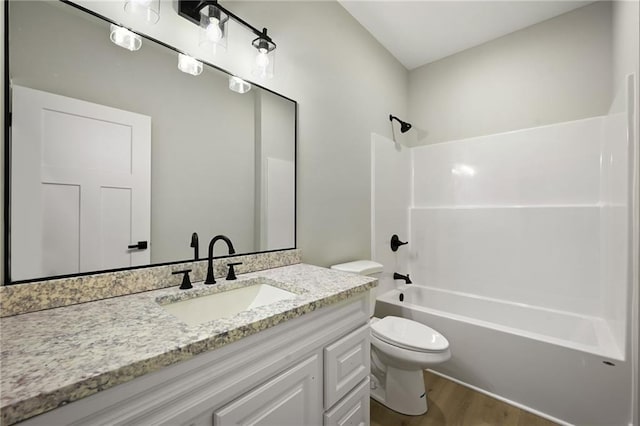 bathroom featuring vanity, shower / tub combination, toilet, and wood finished floors