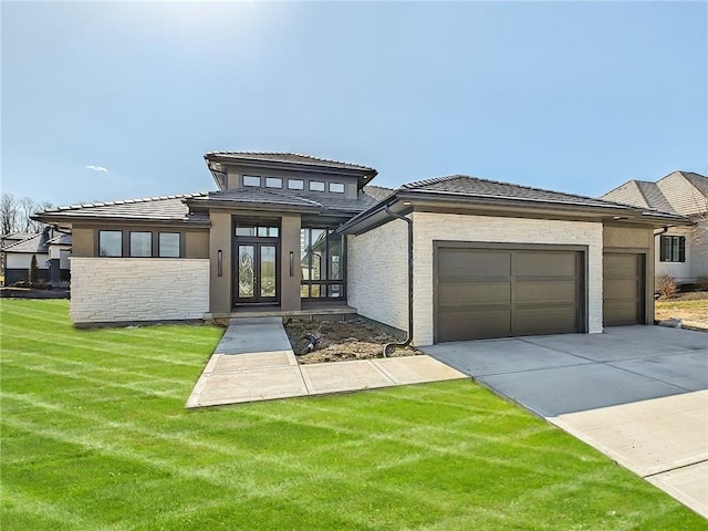 6101 NW 58th St, Kansas City, MO 64151 - prairie-style house with a garage, driveway, french doors, a front lawn, and a tile roof